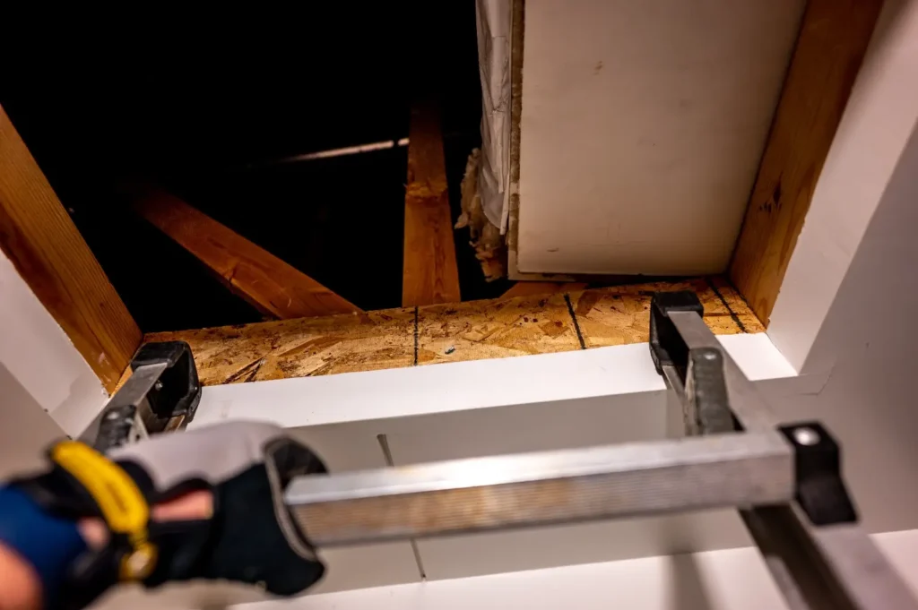 Access hatch opening into a roof void inspected for structural and construction defects